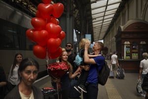 Constantine Semeniuk greets his son, Daniel, and wife, Lesia, with flowers and balloons in Lviv