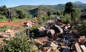 A man in Ngangu, Chimanimani, walks past debris from homes destroyed by Cyclone Idai