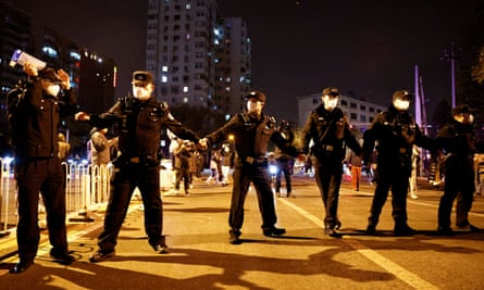 Police officers stand guard as people protest coronavirus restrictions and hold a vigil for the victims of a fire in Urumqi, in Beijing, China, in November 2022.