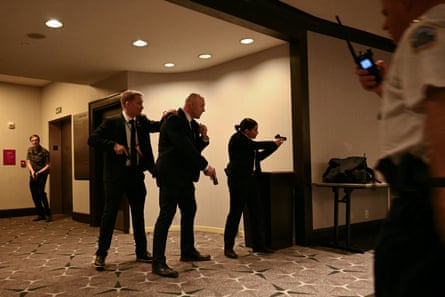 Agents draw their guns after loud bangs were heard during the White House correspondents’ dinner at the Washington Hilton