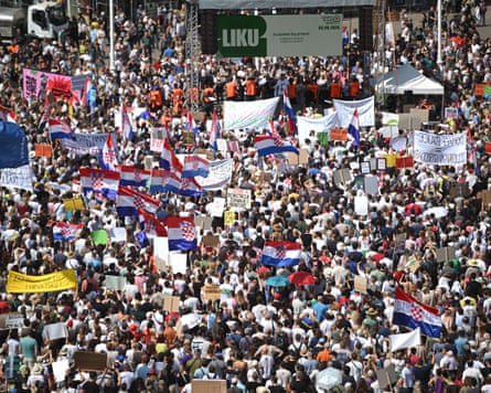 A large group of protesters, some waving the national flag of Croatia.