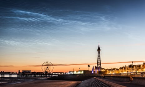 Blackpool landmarks silhouetted against an  orange sunset with streaks of noctilucent cloud visible against the darkening blue sky above