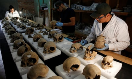 Abel Guzman, Rodrigo Bolanos and Miriam Castaneda, biological anthropologists, examine skulls.