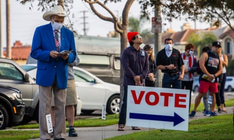 People stand in line to vote as the sun rises in Huntington Beach, California, on 3 November.