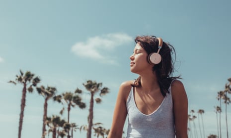Woman on the beach listening to music on headphones