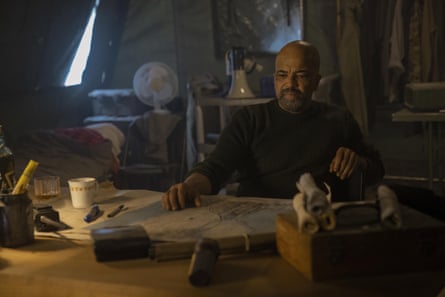 Isaac sits at a table covered in maps