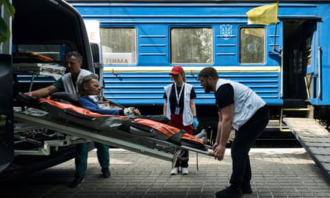 Medical workers carry a patient into a specially equipped railway carriage as the Red Cross evacuates sick people from Pokrovsk.