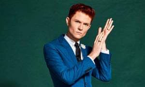 Comedian Rhys Nicholson looking at the camera rubbing his hands.