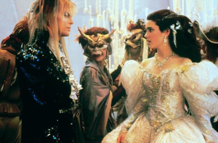 A man with heavy eye makeup and a blond mullet faces off with a girl in a ballgown.