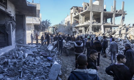 Civil defence teams and Palestinians conduct search and rescue operations among the rubble in Rafah