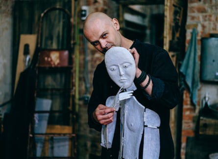 Kostiantyn Zorkin holds a puppet, one of his pieces of art