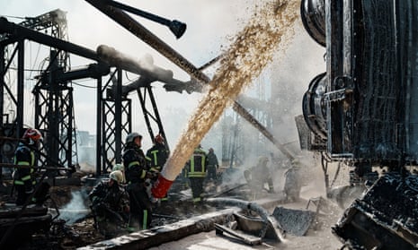 Firefighters try to put out a fire at a power station hit by a Russian missile in Kyiv, 10 October.