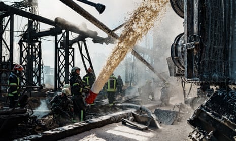 Firefighters work to put out a fire at a power station hit by Russian missiles on Monday