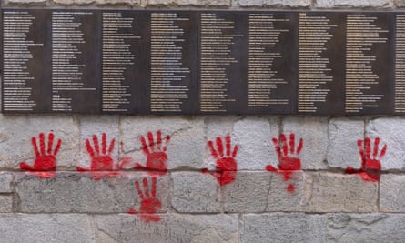 Memorial wall with names and hand prints below in blood