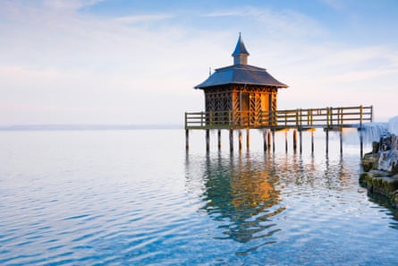 A small bathouse on pier over a lake.