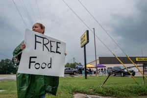 a person holds a sign that reads ‘free food’