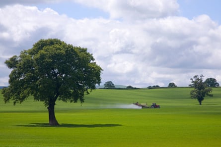 A tractor sprays insecticide on to fields in Shropshire, England