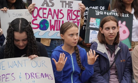 Greta Thunberg, centre, pictured with activists outside the UN earlier this month, will address massed protesters at the climate strike in New York on Friday