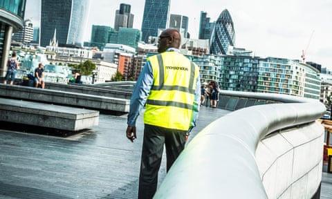 A security guard patrols on Queen’s Walk, part of the More London development near London City Hall. 
