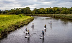 Six Girls paddleboarding on a river in Northern Ireland