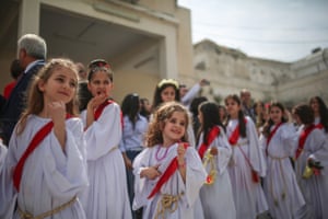 children in white dresses and red sashes