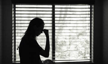 Tired woman standing next to bedroom window