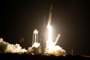 A SpaceX Falcon 9 rocket, with the Crew Dragon capsule, is launched.