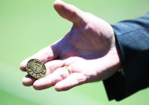 Match referee David Boon hold the coin.