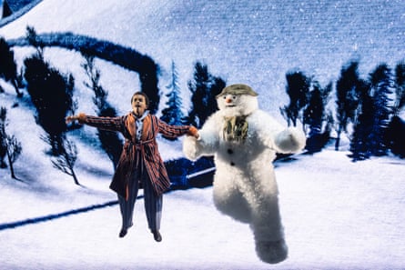 The Boy and The Snowman fly together above a snowy landscape in The Snowman stage show