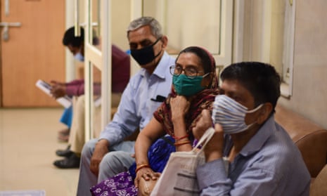 People wait for coronavirus vaccines in Delhi.