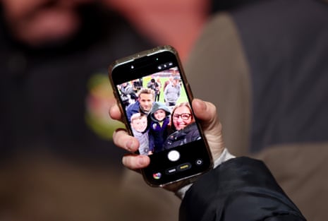 A detailed view of a mobile phone as Ryan Reynolds, Canadian-American actor, entrepreneur and co-owner of Wrexham, poses for a selfie with members of the crowd.