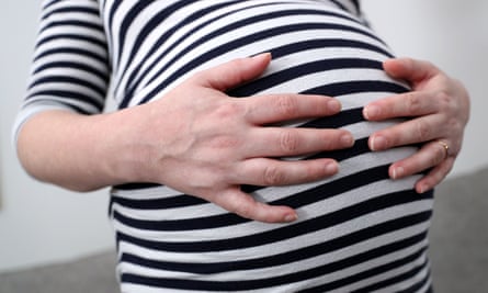 A pregnant woman holding her stomach