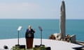 Joe Biden makes a speech from a lecturn with the sea behind him