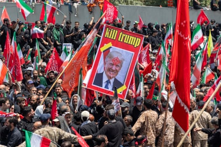 A picture of Donald Trump with a target on his head and with writing 'kill Trump' is held aloft during the funeral procession for Ali Khamenei in Tehran.