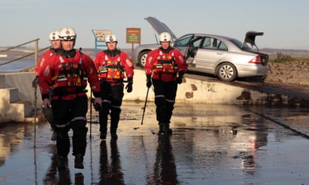 Humberside Fire and Rescue officers check a flood-damaged car in 2013.