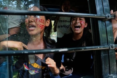 Exiled Tibetans shout slogans from a police vehicle after being detained during a protest outside the Chinese Embassy on China’s national day in New Delhi