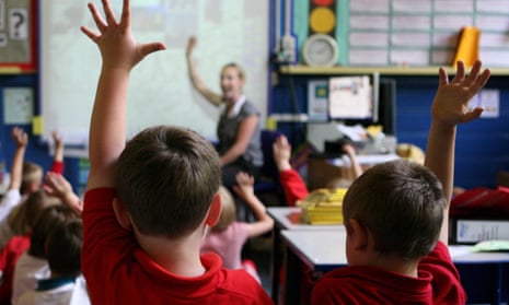 children at school raising their hands to answer a question