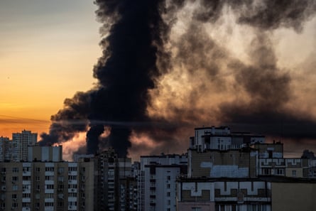 Smoke rises over multi-storey building against an early morning sky