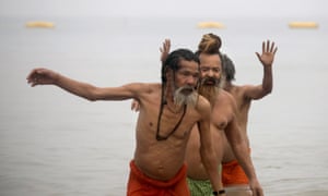 Indian monks take a holy dip as devotees gather at the Ganges River.