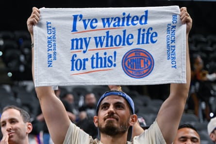 A Knicks instrumentality holds up a towel that says 'I've waited my full life for this!' astatine an NBA finals game.