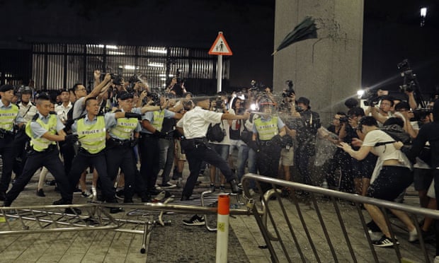 Police officers use pepper spray against protesters in Hong Kong.