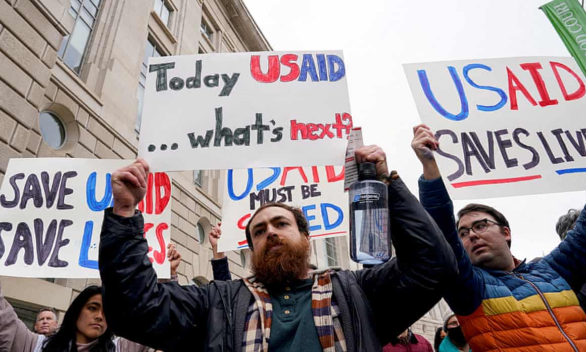 People holding placards including one that says: Today USAid ... what's next?
