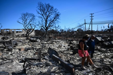 Davilynn Severson and Hano Ganer look for belongings through the ashes of their family’s home in the aftermath of a wildfire in Lahaina, western Maui, Hawaii on August 11, 2023.