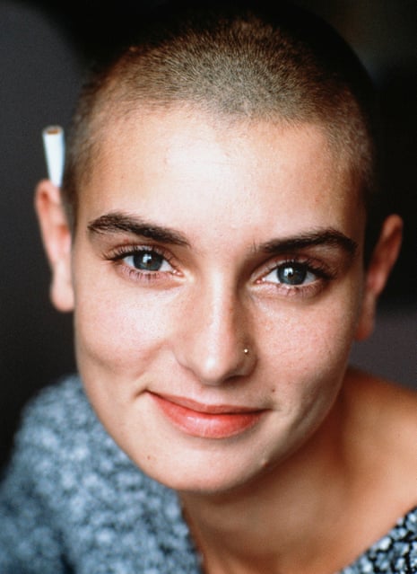 Sinéad O'Connor in 1992, bright-eyed and with close-shaven hair and a silver nose stud, looks up, smiling