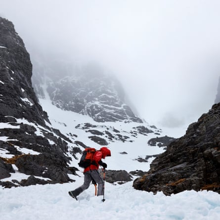 A person walks through snow by the gully
