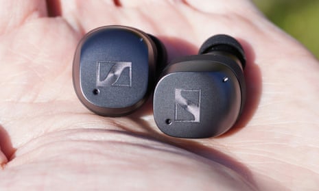 A pair of Sennheiser Momentum True Wireless 3 earbuds in the palm of a hand