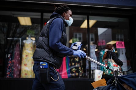 A postal worker wears a protective mask and gloves while operating a route in the Queens borough of New York.