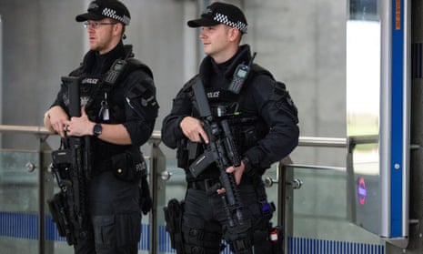 Armed police patrol Westminster tube station after a terrorist attack.