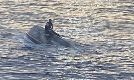 man sits on overturned boat