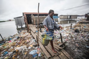 Roselyn Kwesi on her way home after using a bathing and toilet facility that empties straight into the water in Fanti Town, Monrovia, Liberia.